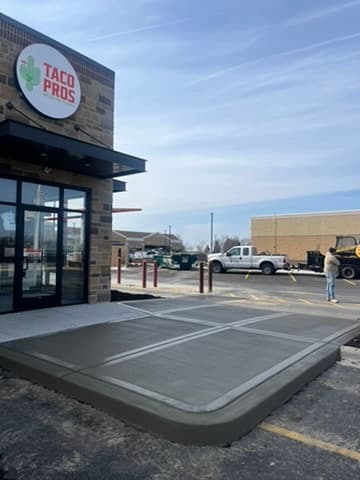 Freshly poured and finished concrete pad at Taco Pros restaurant entrance