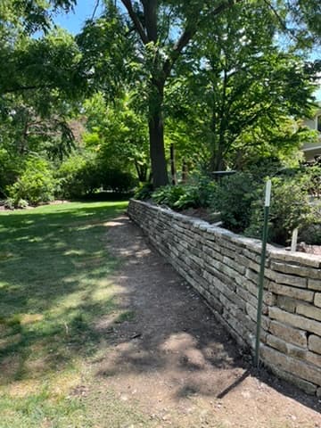 Curved natural stone retaining wall blending seamlessly with landscape