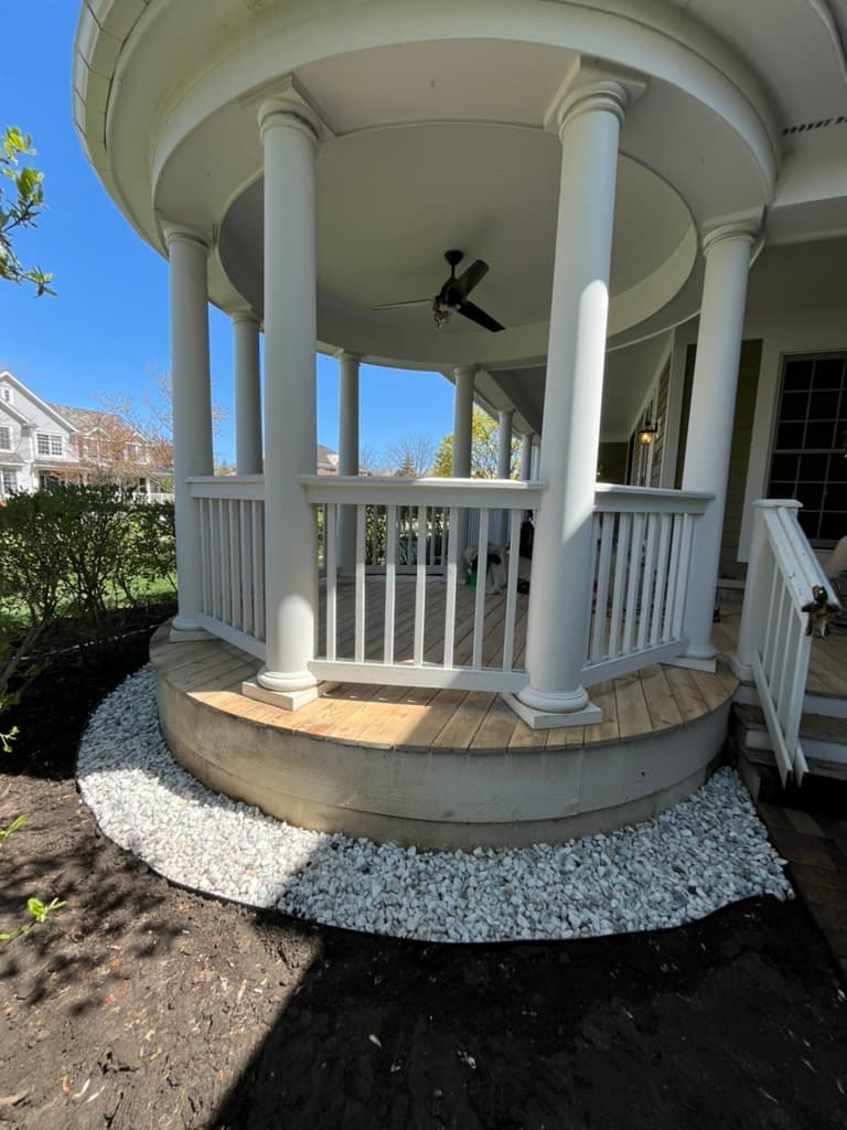 Curved concrete steps and white gravel border enhancing classic gazebo