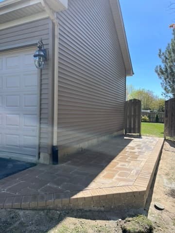Dual-tone paver walkway with brick border along side of home